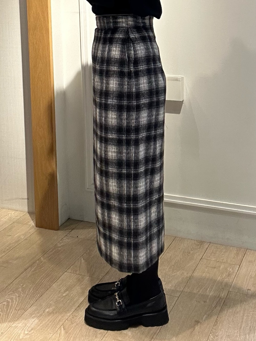 ホワイト系のトートバッグ、ホワイト系のテーラードジャケット、ブラック系のニット/セーターを着用したレディースの冬コーディネートの8枚目の写真