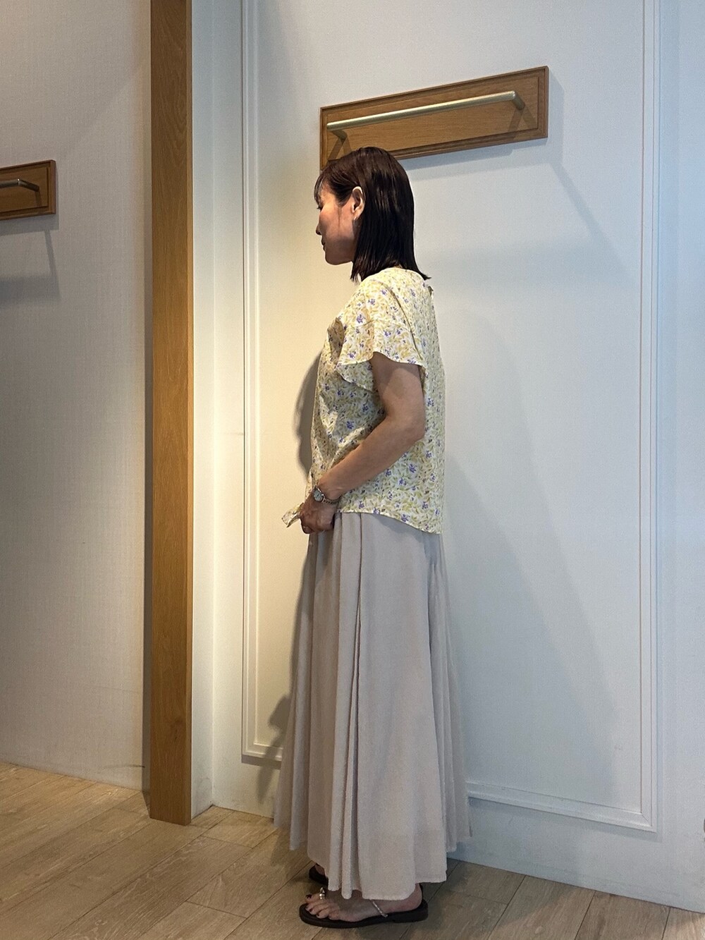 ホワイト系のスカート、イエロー系のシャツ/ブラウス、ゴールド系のネックレスを着用したレディースの春コーディネートの2枚目の写真