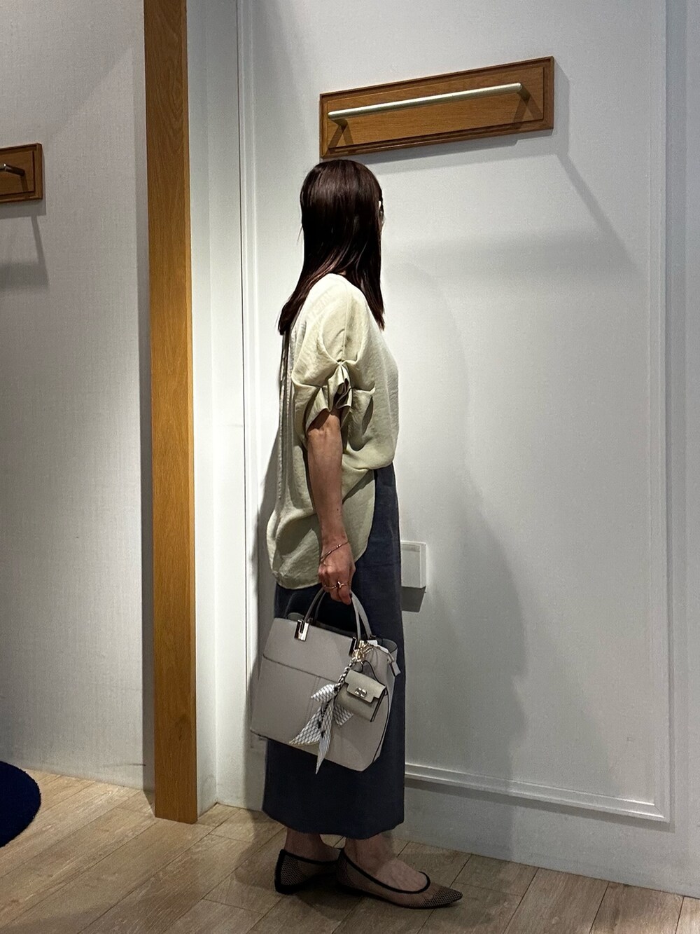 イエロー系のシャツ/ブラウス、ブルー系のスカート、グレー系のTシャツ/カットソーを着用したレディースの春コーディネートの2枚目の写真