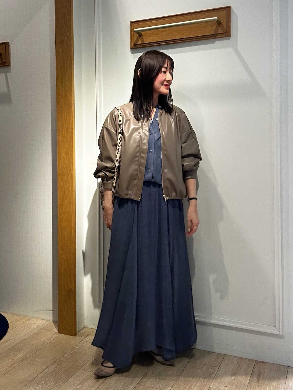 ブルー系のスカート、ブルー系のシャツ/ブラウス、グリーン系のブルゾンを着用したレディースの春コーディネートの3枚目の写真