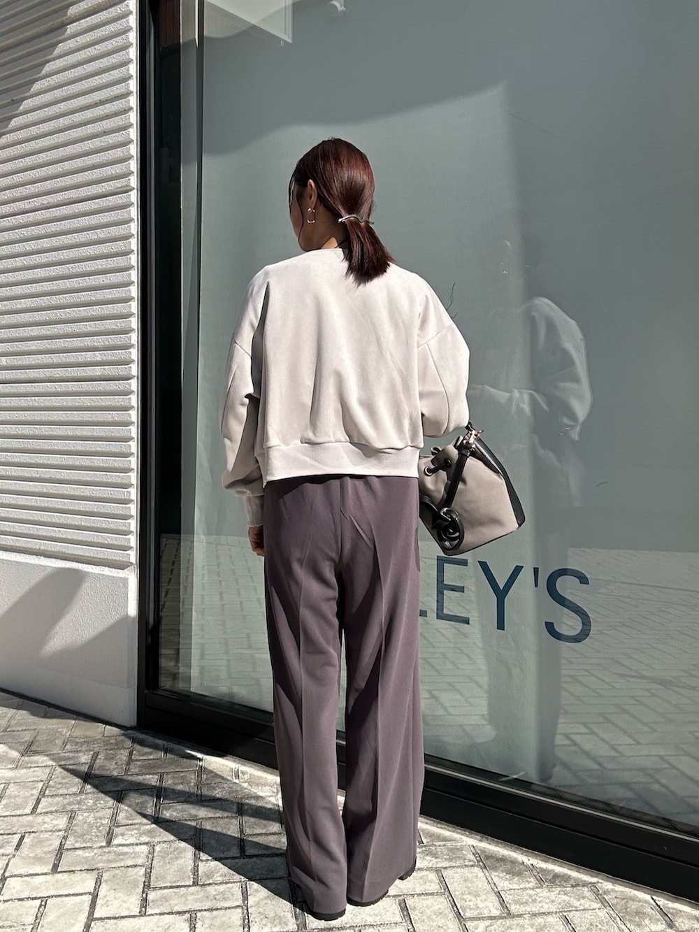 グレー系のその他パンツ、グレー系のニット/セーター、ベージュ系のブルゾンを着用したレディースの秋コーディネートの3枚目の写真