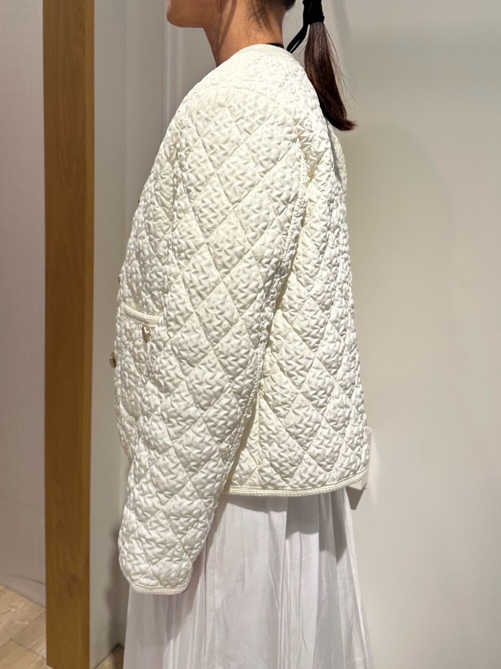 ホワイト系のブルゾン、ブルー系のニット/セーター、ホワイト系のスカートを着用したレディースの冬コーディネートの6枚目の写真