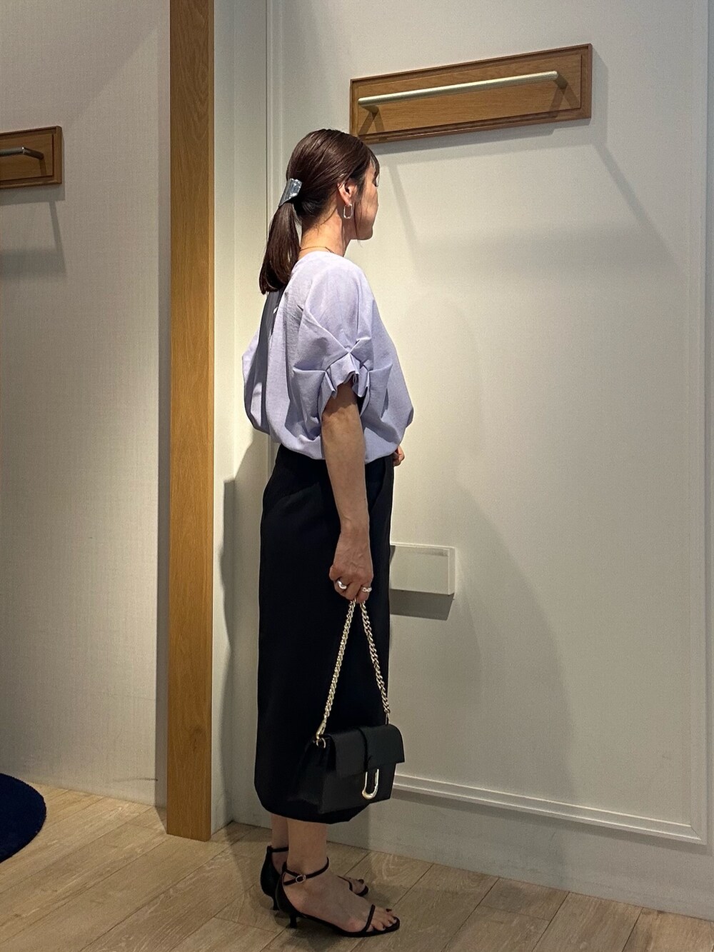 パープル系のシャツ/ブラウス、ブルー系のスカート、ブラック系のショルダーバッグを着用したレディースの春コーディネートの4枚目の写真