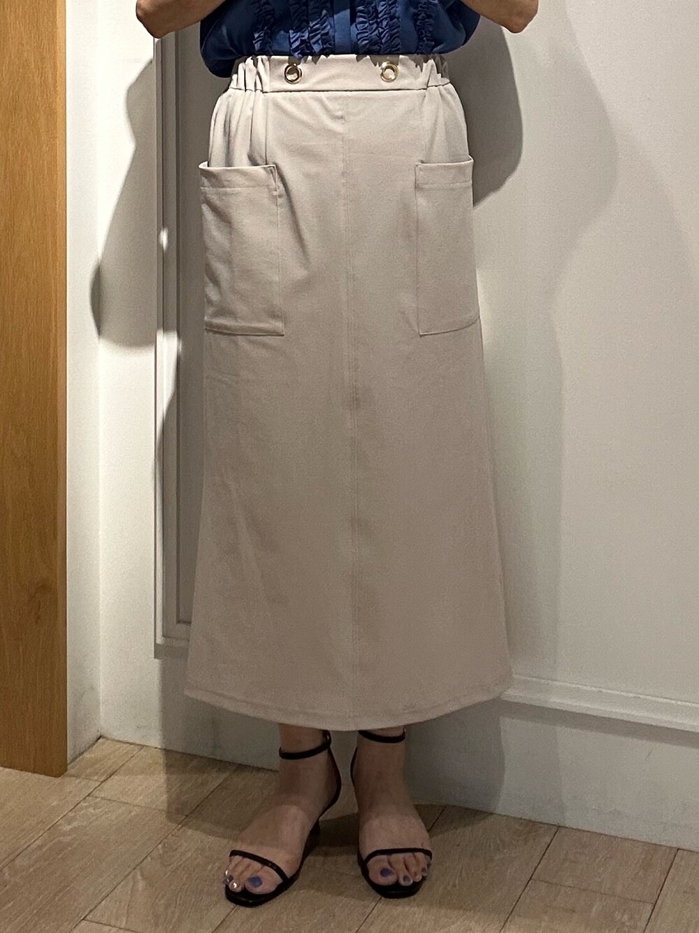 ベージュ系のスカート、ブラック系のショルダーバッグ、ブラック系のサンダルを着用したレディースの夏コーディネートの8枚目の写真