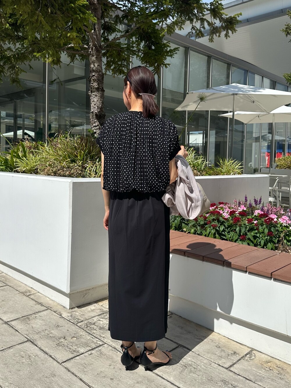 ブラック系のシャツ/ブラウス、ブラック系のスカート、ベージュ系のボストンバッグを着用したレディースの夏コーディネートの3枚目の写真