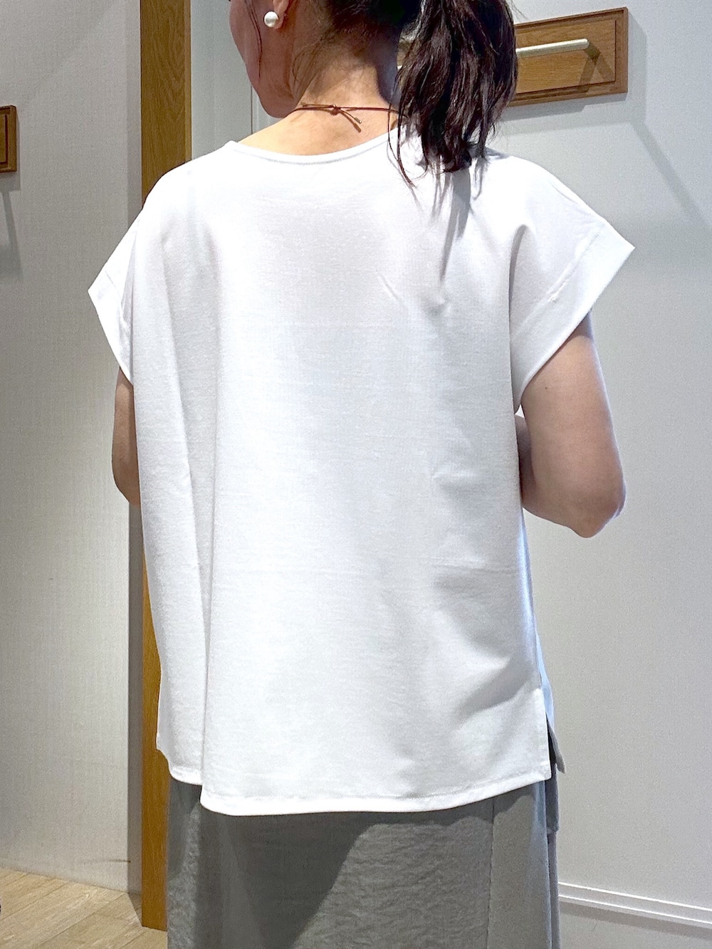 ホワイト系のTシャツ/カットソー、グリーン系のスカート、ブラック系のブルゾンを着用したレディースの春コーディネートの9枚目の写真