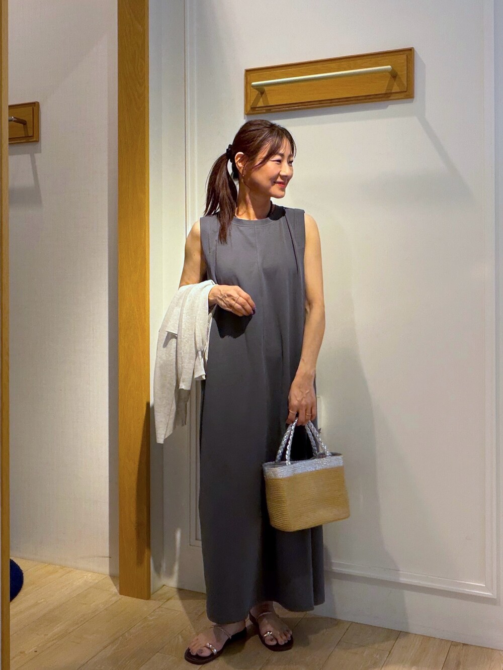 ベージュ系のカーディガン/ボレロ、グレー系のワンピース、ブラック系のネックレスを着用したレディースの夏コーディネートの5枚目の写真