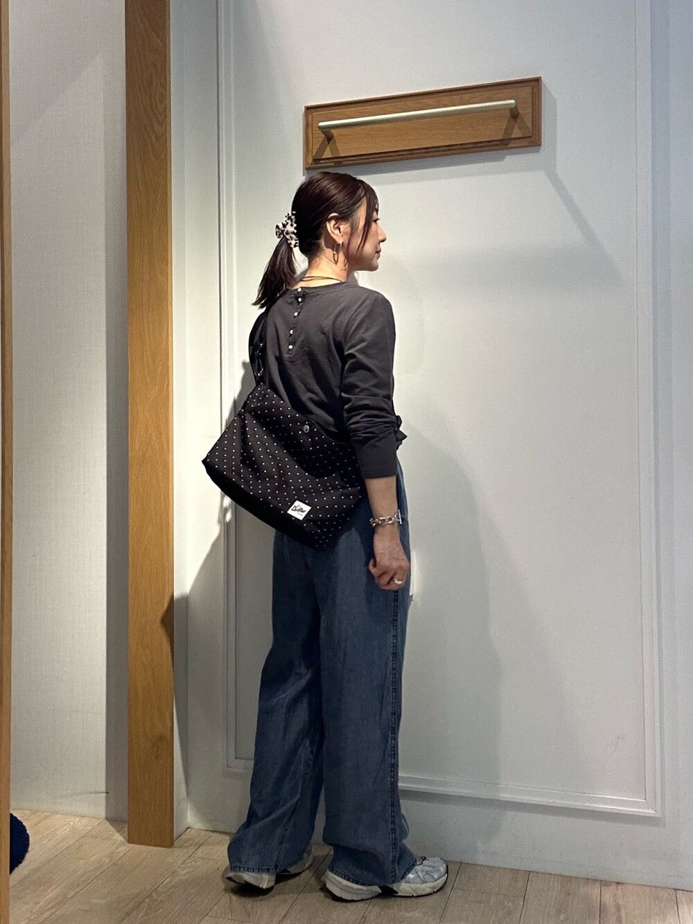 グレー系のTシャツ/カットソー、ブルー系のデニムパンツ、ブラウン系のブルゾンを着用したレディースの秋コーディネートの4枚目の写真