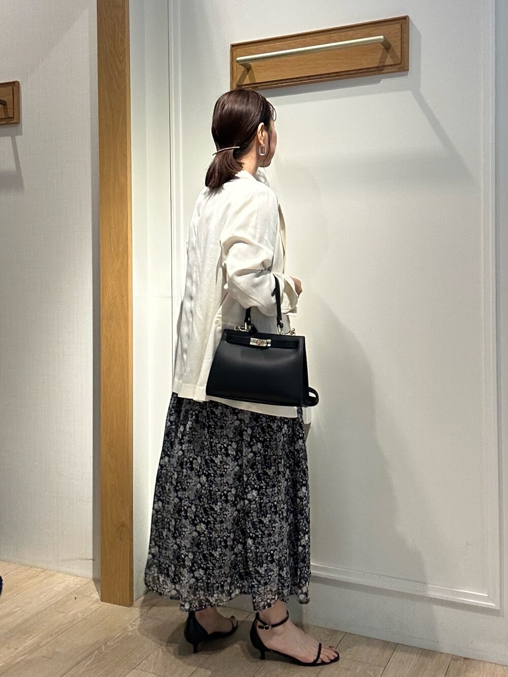 ブラック系のワンピース、ホワイト系のテーラードジャケット、ブラック系のショルダーバッグを着用したレディースの夏コーディネートの3枚目の写真