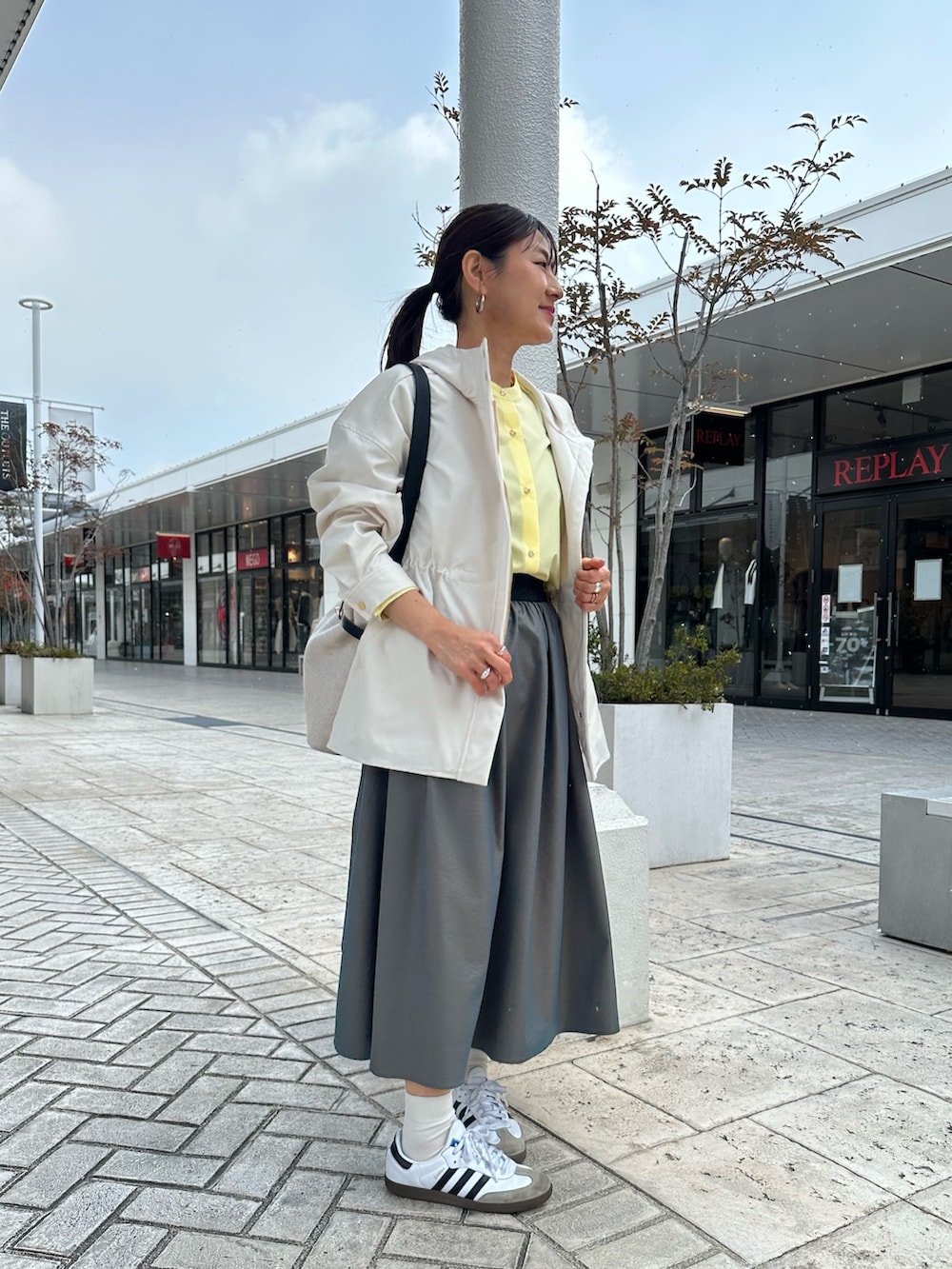 ホワイト系のブルゾン、イエロー系のシャツ/ブラウス、グリーン系のスカートを着用したレディースの冬コーディネートの4枚目の写真
