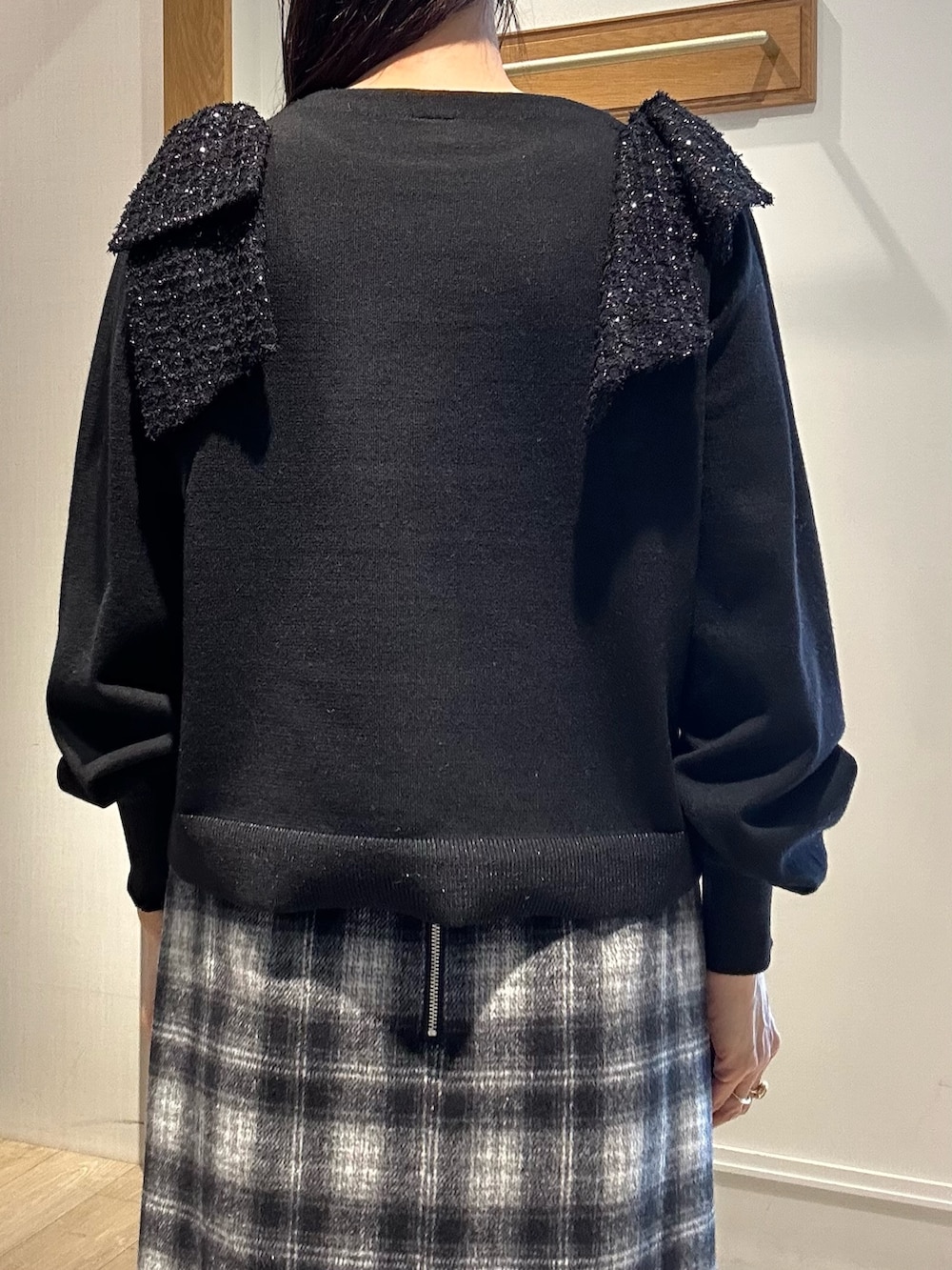 ブラック系のニット/セーター、ブルー系のスカート、ホワイト系のトートバッグを着用したレディースの冬コーディネートの7枚目の写真