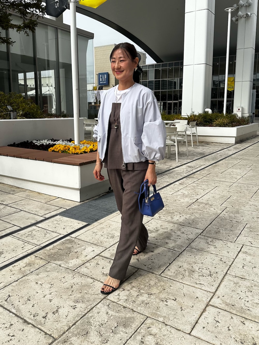 グリーン系のシャツ/ブラウス、ブルー系のブルゾン、ブルー系のショルダーバッグを着用したレディースの春コーディネートの10枚目の写真