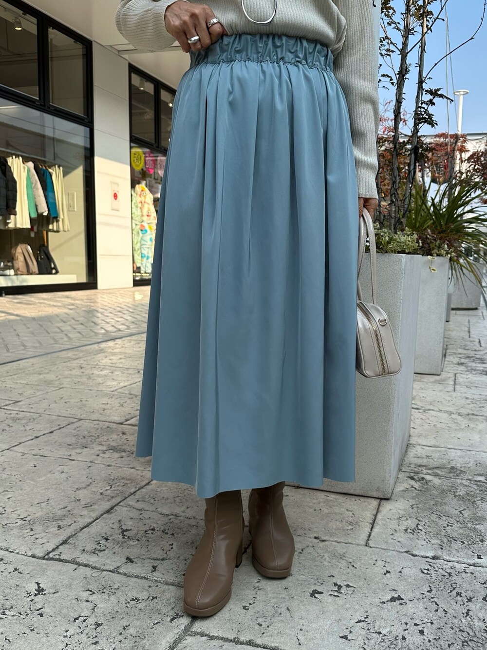 ホワイト系のノーカラージャケット、ベージュ系のスカート、ホワイト系のTシャツ/カットソーを着用したレディースの冬コーディネートの7枚目の写真