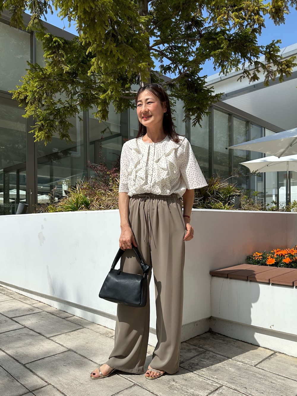グリーン系のその他パンツ、ブラック系のショルダーバッグ、ホワイト系のシャツ/ブラウスを着用したレディースの春コーディネートの7枚目の写真