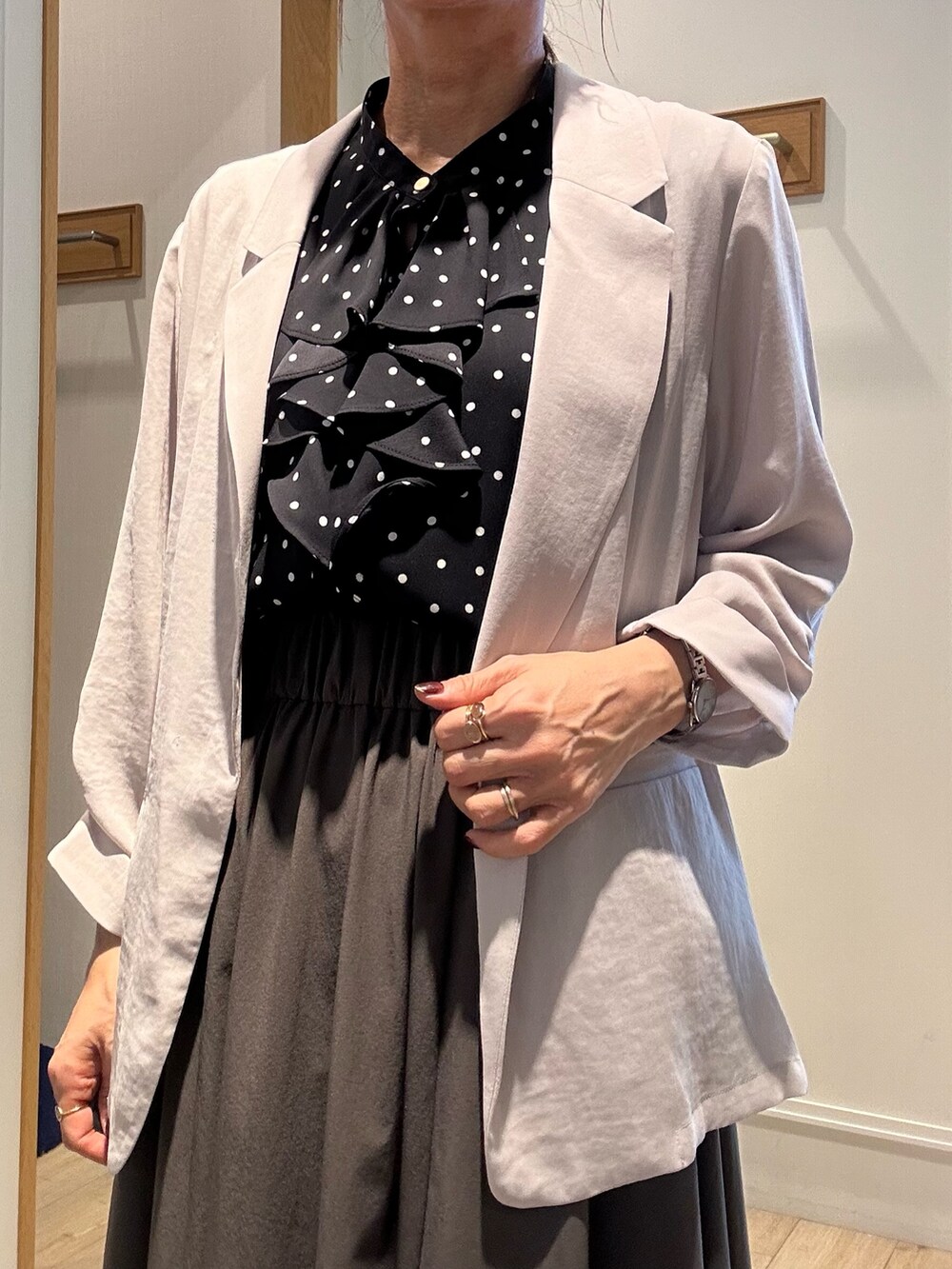 ベージュ系のテーラードジャケット、ベージュ系のボストンバッグ、ブラック系のサンダルを着用したレディースの夏コーディネートの6枚目の写真