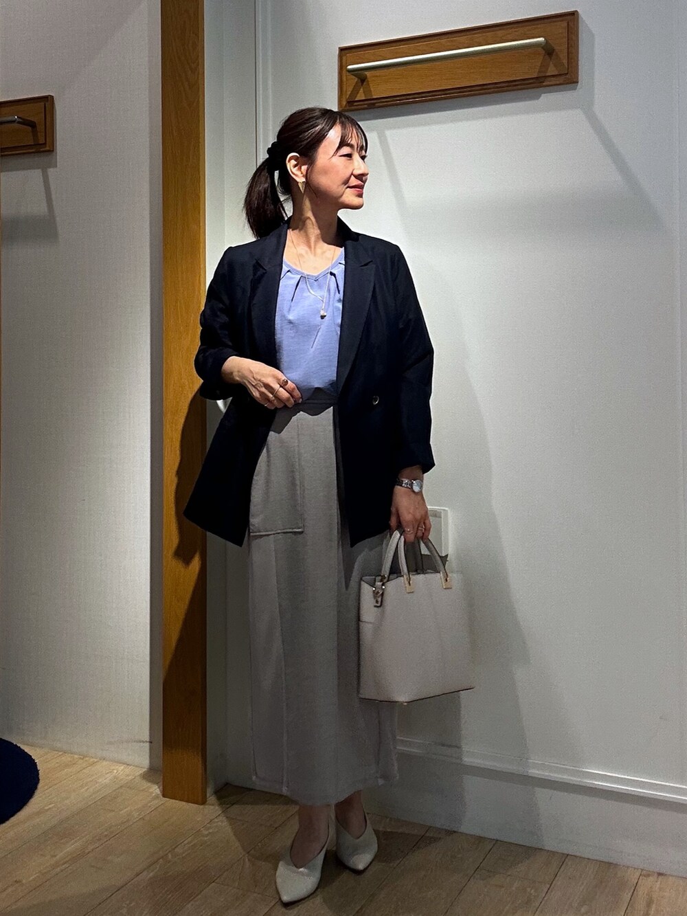 ブルー系のシャツ/ブラウス、ブルー系のテーラードジャケット、グレー系のスカートを着用したレディースの春コーディネートの4枚目の写真