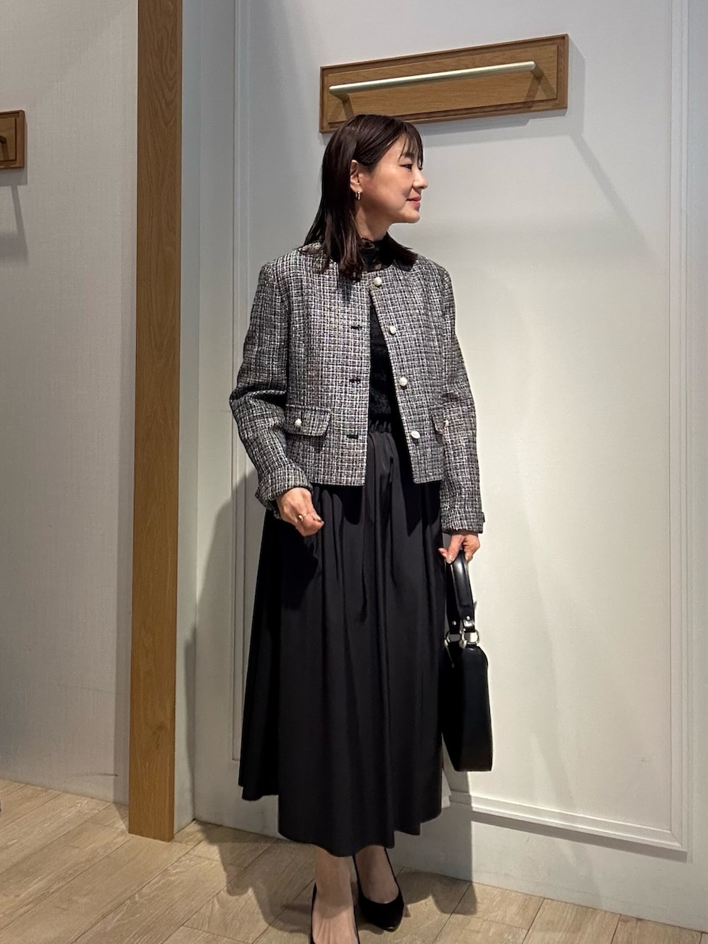 ブラック系のノーカラージャケット、ブラック系のTシャツ/カットソー、ブルー系のスカートを着用したレディースの冬コーディネートの8枚目の写真