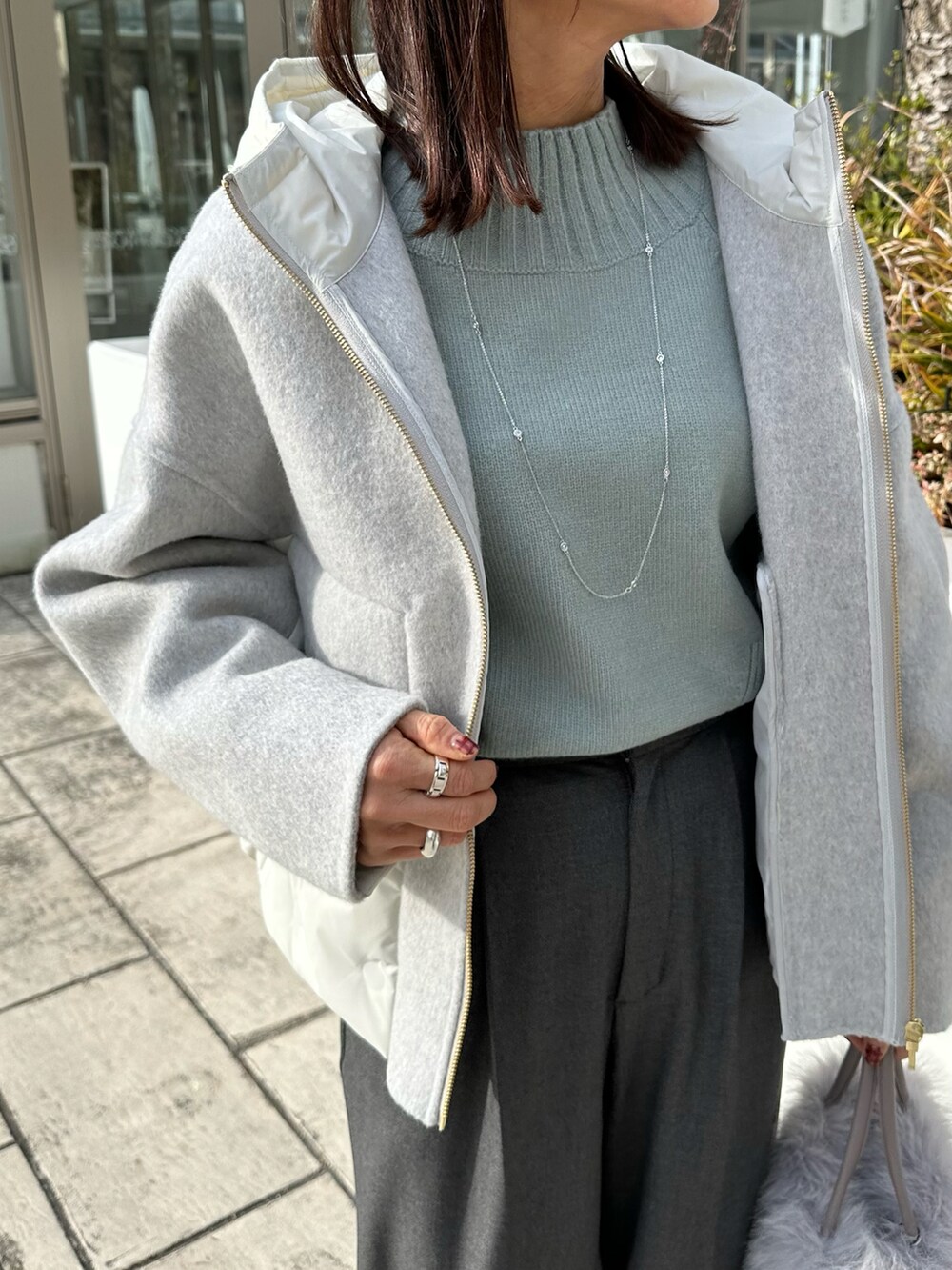 グレー系のその他アウター、オレンジ系のニット/セーターを着用したレディースの冬コーディネートの3枚目の写真