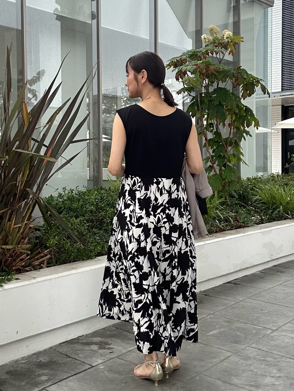 ホワイト系のワンピース、ブラック系のショルダーバッグ、ベージュ系のテーラードジャケットを着用したレディースの夏コーディネートの3枚目の写真