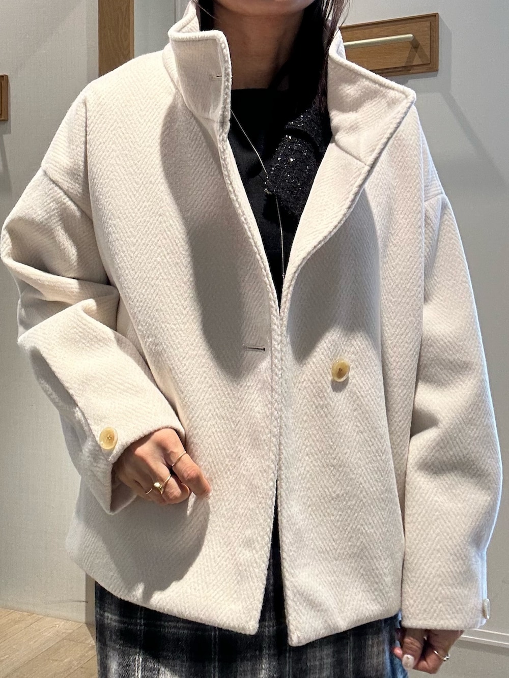 ホワイト系のトートバッグ、ホワイト系のテーラードジャケット、ブラック系のニット/セーターを着用したレディースの冬コーディネートの4枚目の写真