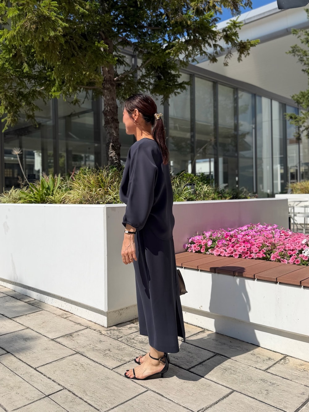 グレー系のシャツ/ブラウス、グレー系のスカート、ベージュ系のショルダーバッグを着用したレディースの夏コーディネートの2枚目の写真
