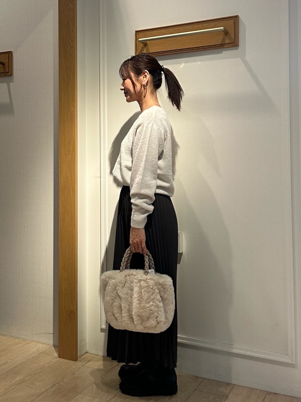 ホワイト系のニット/セーター、グレー系のスカート、ホワイト系のトートバッグを着用したレディースの秋コーディネートの2枚目の写真