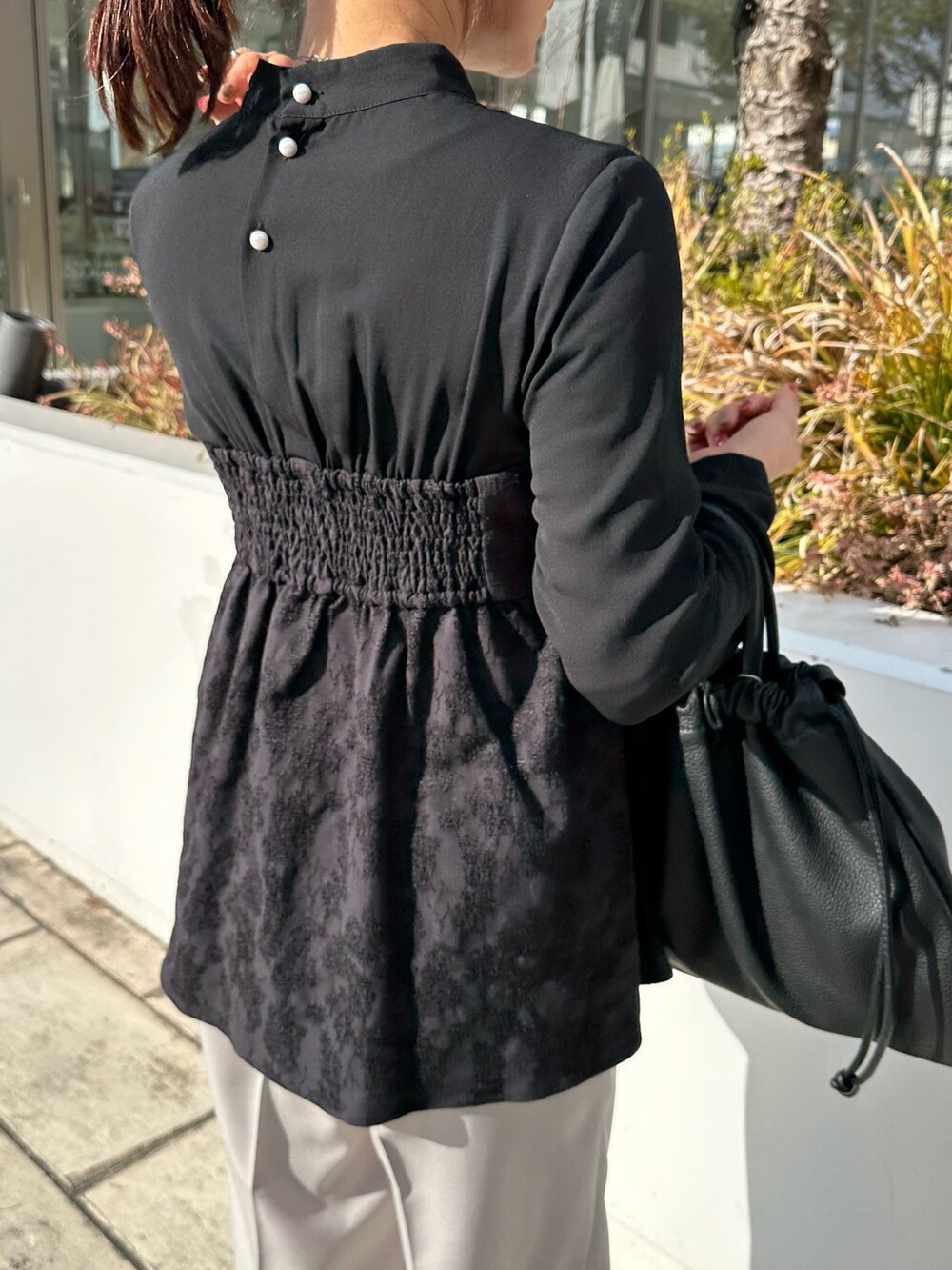 ブラック系のシャツ/ブラウス、ベージュ系のその他パンツ、ブラック系のショルダーバッグを着用したレディースの冬コーディネートの6枚目の写真
