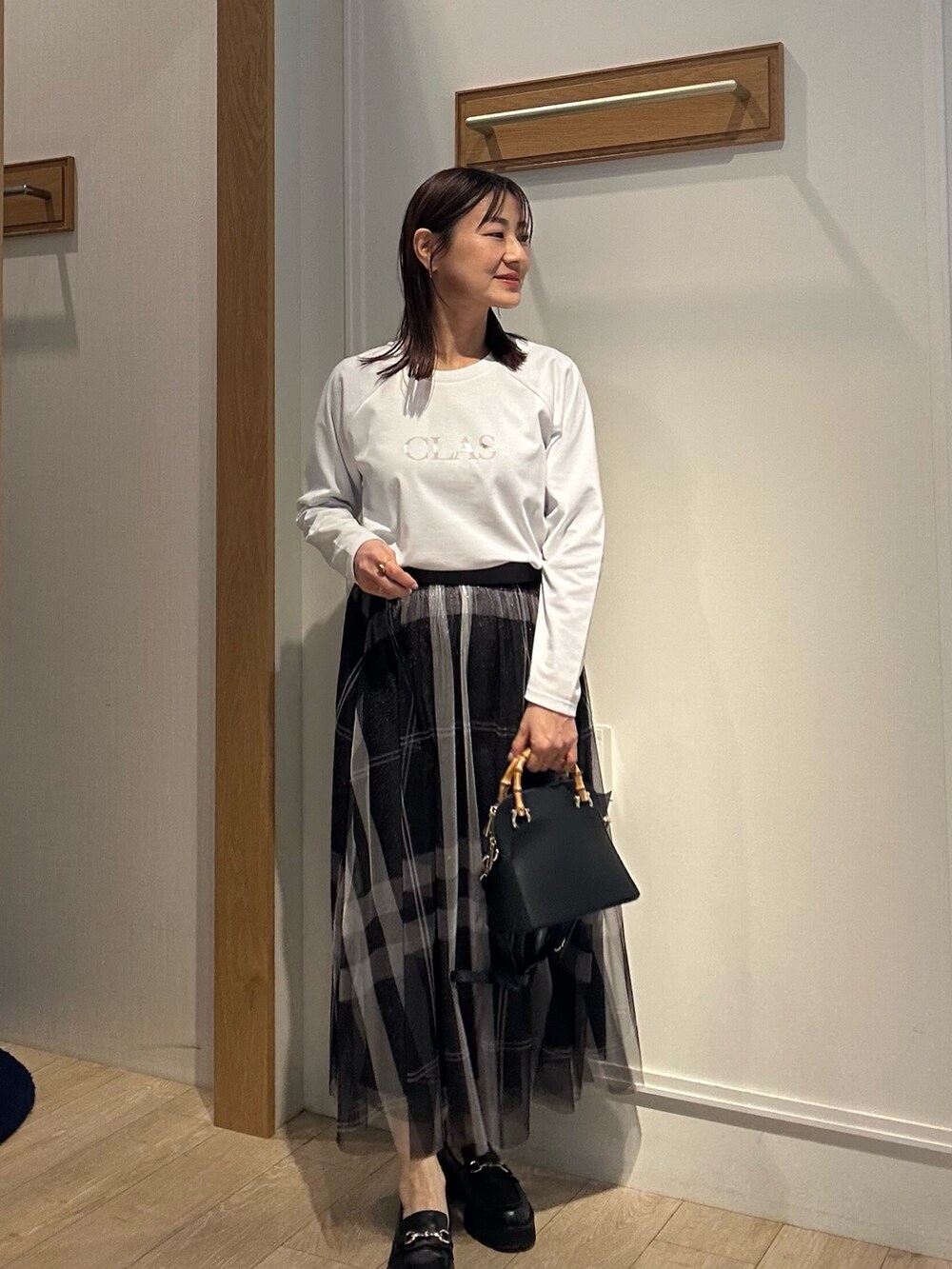 ホワイト系のTシャツ/カットソー、グレー系のスカートを着用したレディースの冬コーディネートの2枚目の写真