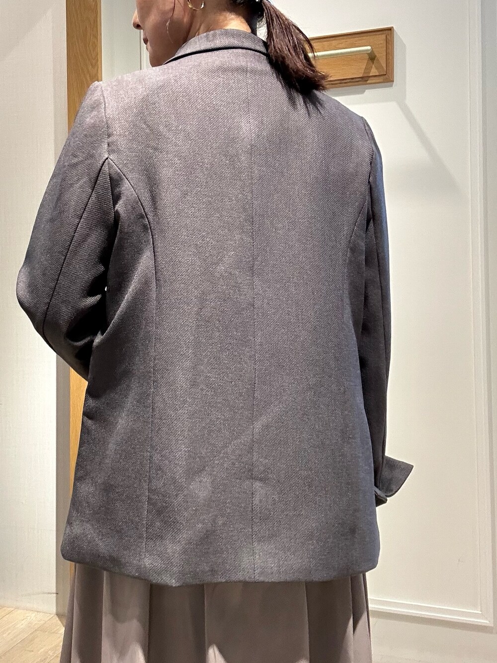 グレー系のテーラードジャケット、ブラウン系のスカート、ブルー系のシャツ/ブラウスを着用したレディースの秋コーディネートの8枚目の写真