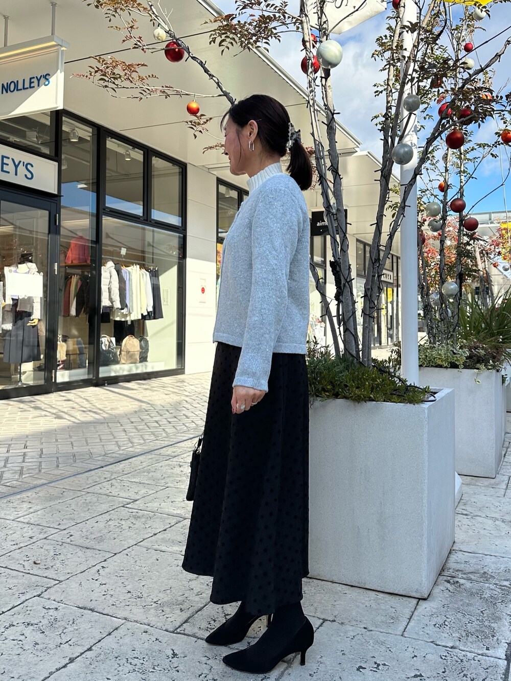 グレー系のニット/セーター、ブラック系のショルダーバッグを着用したレディースの冬コーディネートの3枚目の写真