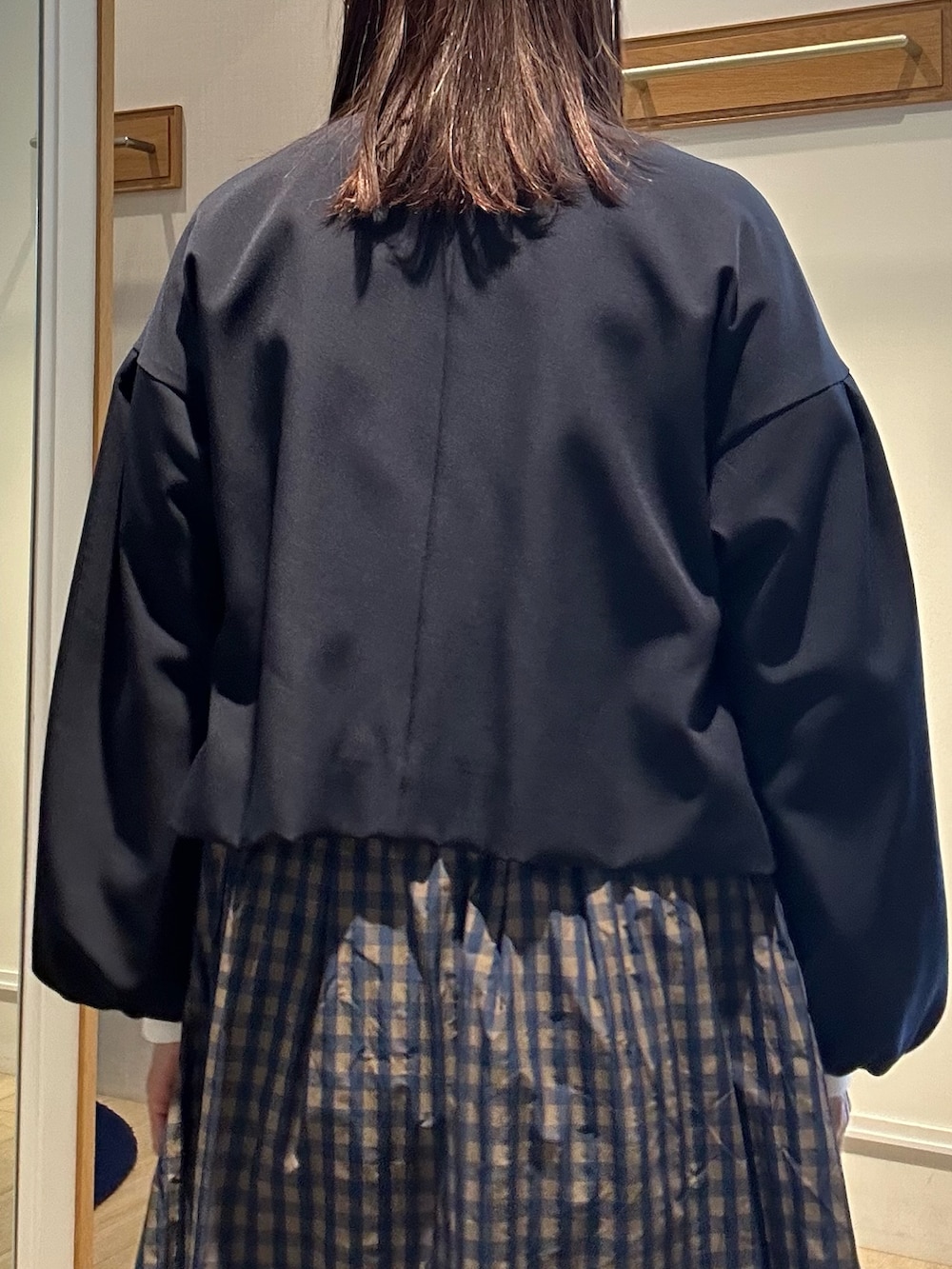 ブルー系のノーカラージャケット、ホワイト系のTシャツ/カットソー、ブラウン系のスカートを着用したレディースの冬コーディネートの7枚目の写真