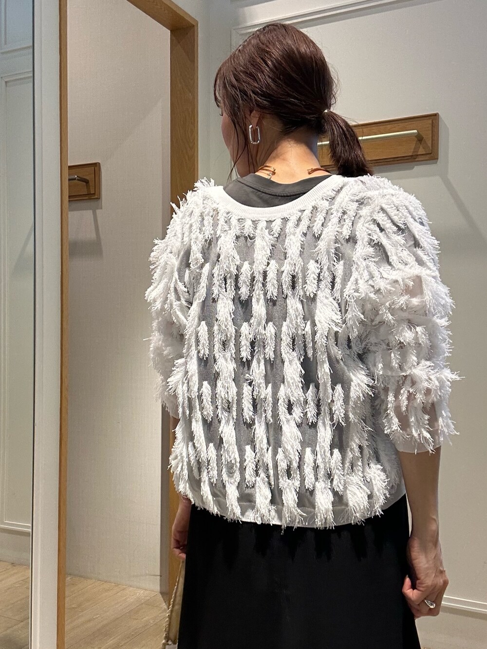 ホワイト系のカーディガン/ボレロ、ブラック系のワンピース、ゴールド系のネックレスを着用したレディースの夏コーディネートの8枚目の写真