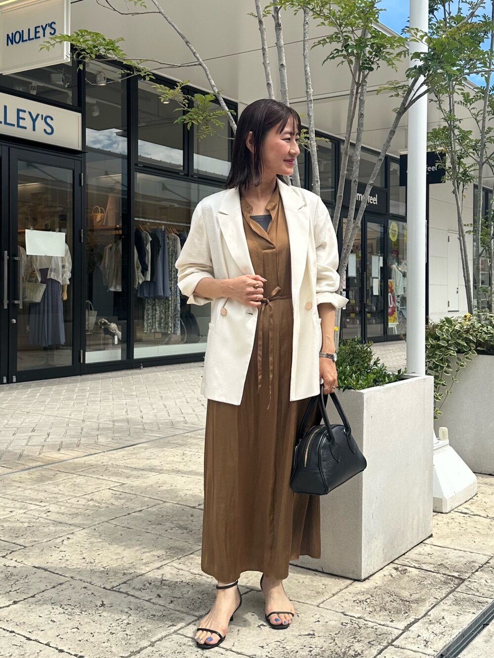 ブラウン系のワンピース、グレー系のTシャツ/カットソー、ホワイト系のテーラードジャケットを着用したレディースの夏コーディネートの6枚目の写真