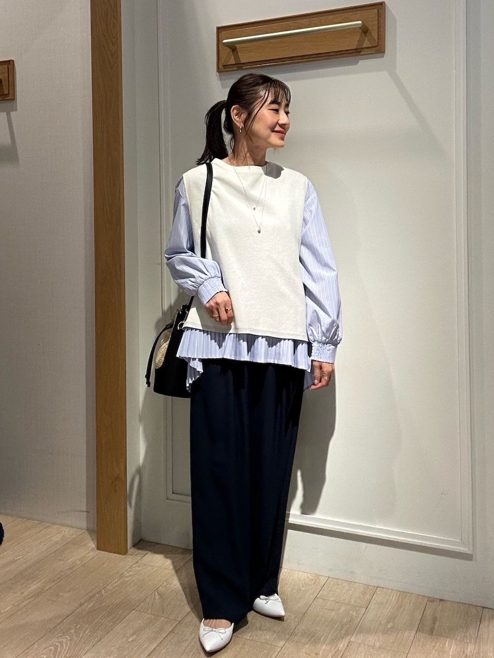 ブラック系のバッグ、ベージュ系のブルゾン、ホワイト系のニット/セーターを着用したレディースの春コーディネートの9枚目の写真