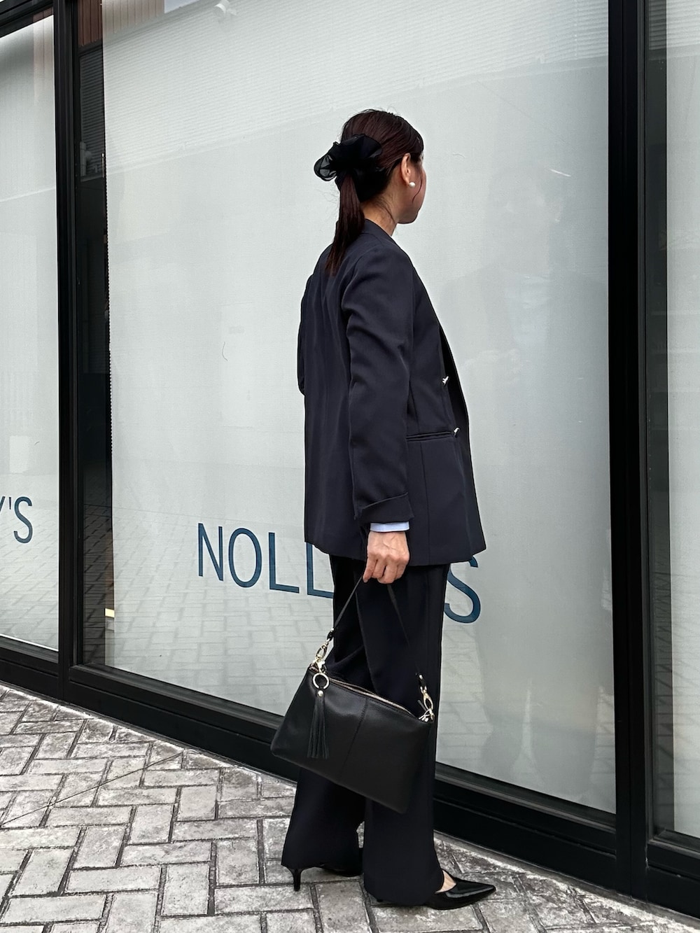 ブルー系のテーラードジャケット、ブルー系のその他パンツ、ブラック系のショルダーバッグを着用したレディースの冬コーディネートの3枚目の写真