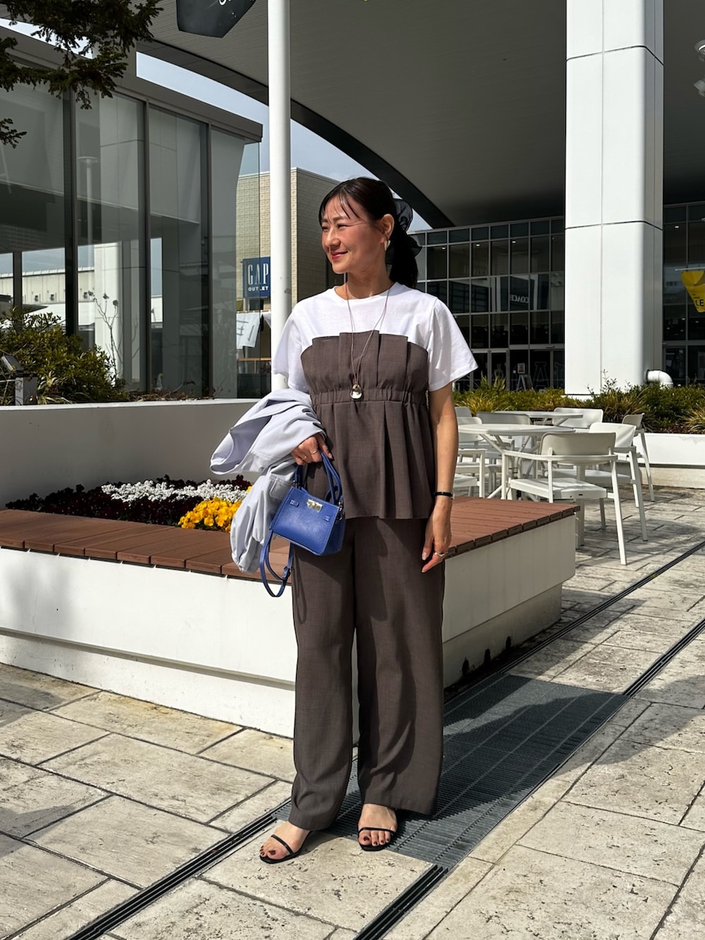 ブルー系のブルゾン、グリーン系のシャツ/ブラウス、ブルー系のショルダーバッグを着用したレディースの春コーディネートの7枚目の写真