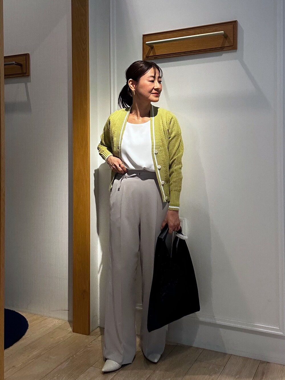 ベージュ系のその他パンツ、イエロー系のカーディガン/ボレロ、ブラック系のブルゾンを着用したレディースの春コーディネートの9枚目の写真