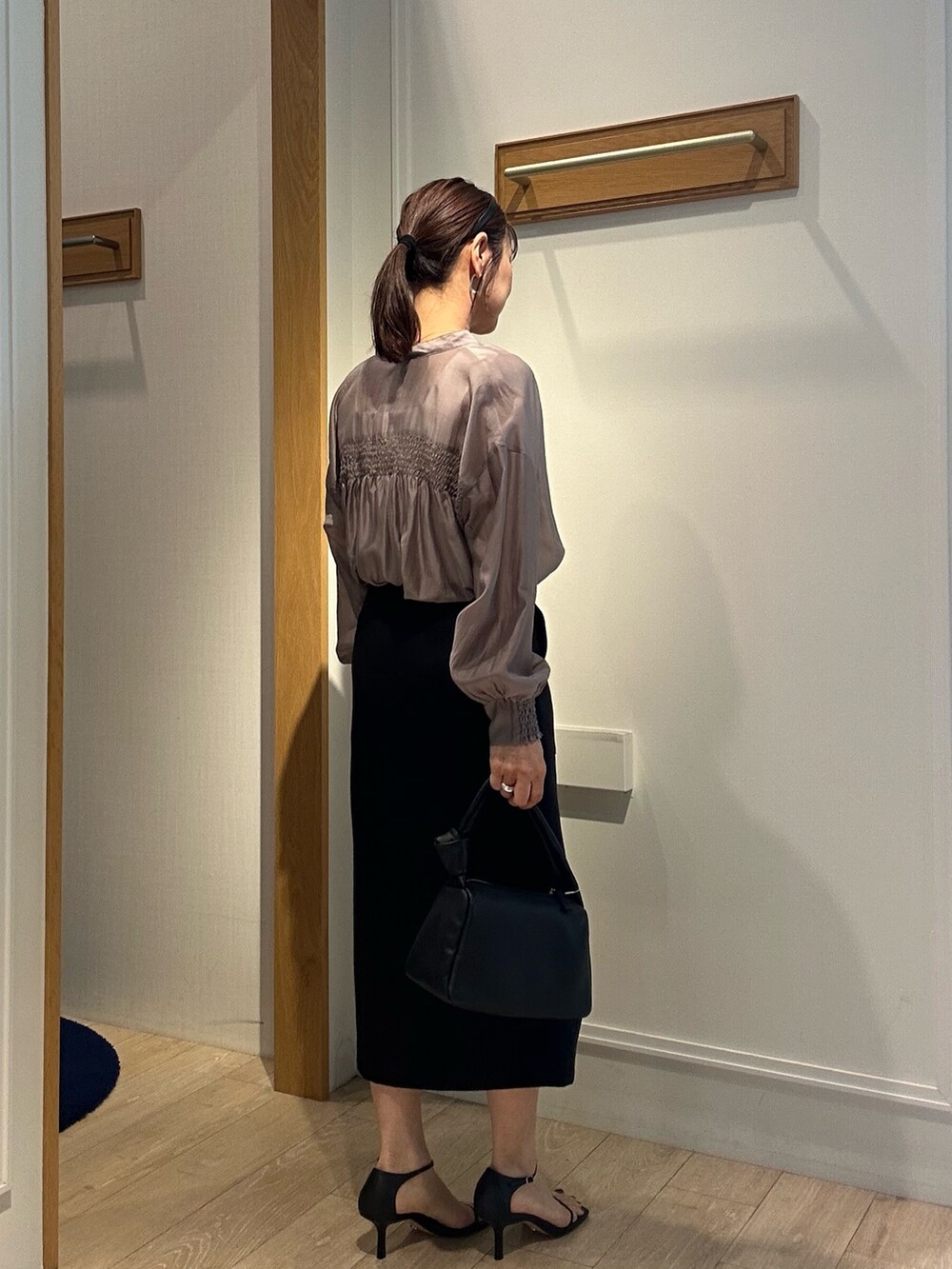 ホワイト系のTシャツ/カットソー、ブラック系のスカートを着用したレディースの春コーディネートの6枚目の写真