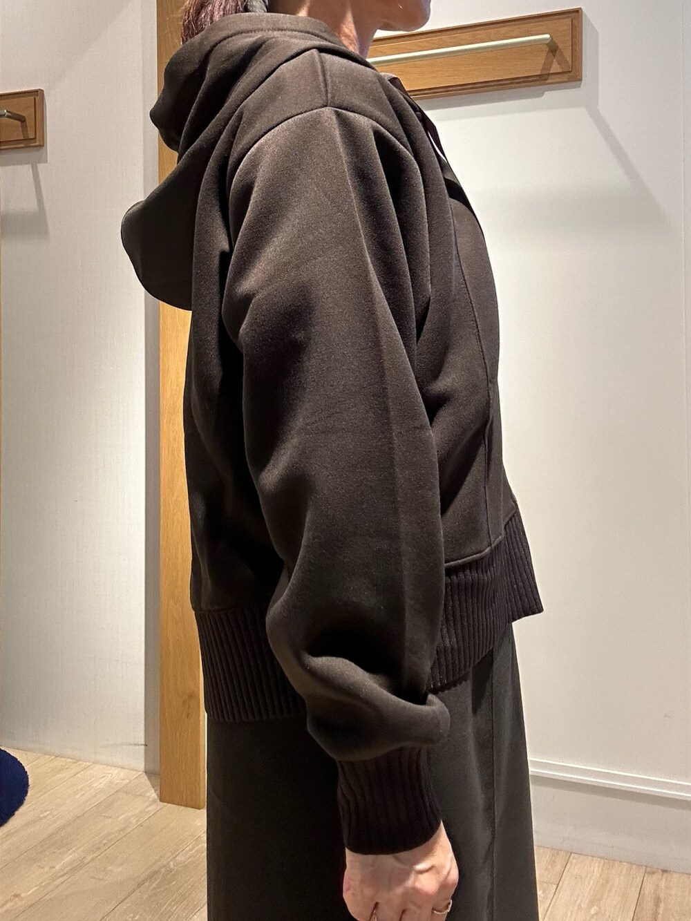 ブラウン系のパーカー、ブラウン系のスカート、ブラック系のショルダーバッグを着用したレディースの秋コーディネートの6枚目の写真