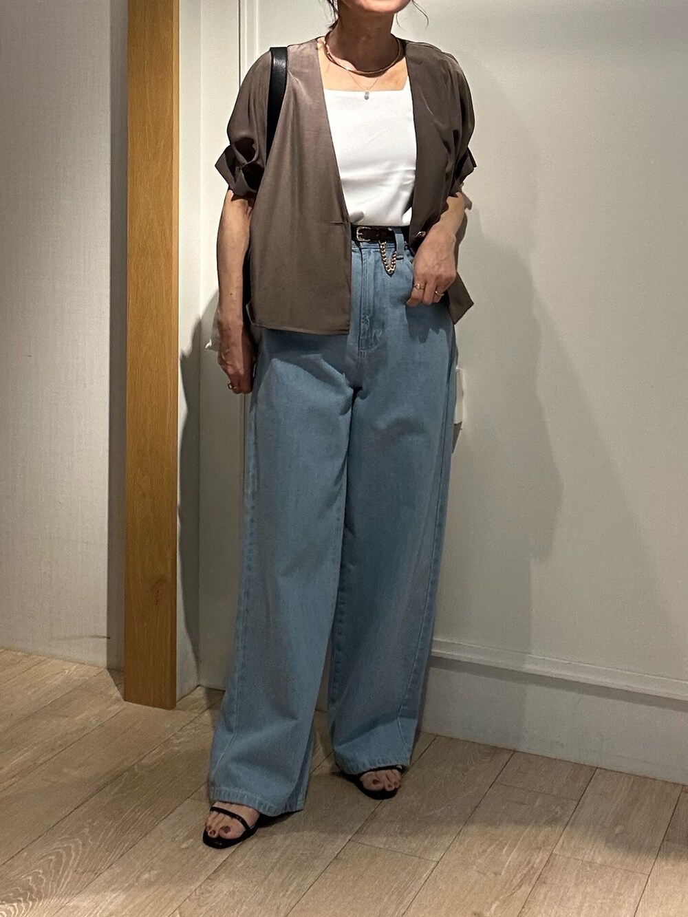 グリーン系のノーカラージャケット、ブルー系のデニムパンツ、ブラック系のサンダルを着用したレディースの夏コーディネートの5枚目の写真