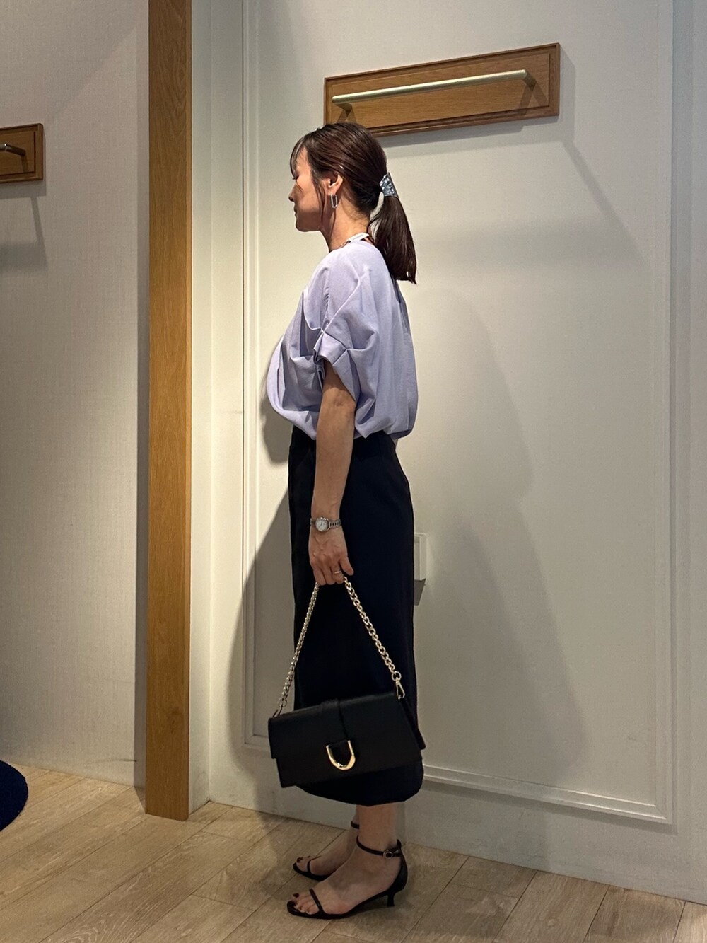 パープル系のシャツ/ブラウス、ブルー系のスカート、ブラック系のショルダーバッグを着用したレディースの春コーディネートの2枚目の写真