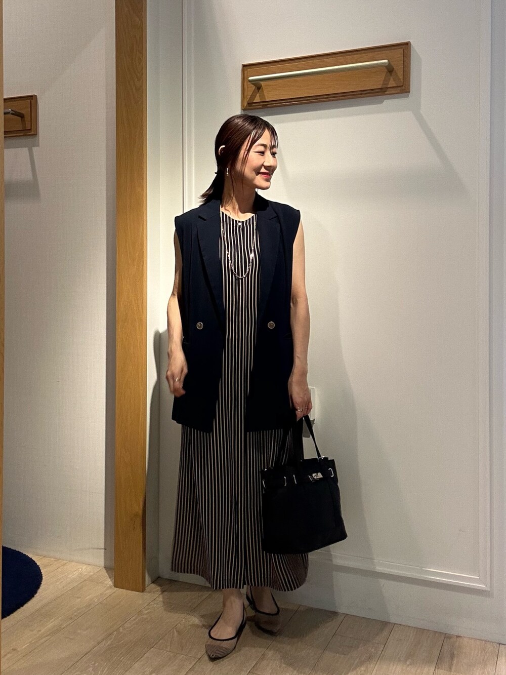 グレー系のテーラードジャケット、ブルー系のテーラードジャケット、ブラック系のトートバッグを着用したレディースの夏コーディネートの9枚目の写真