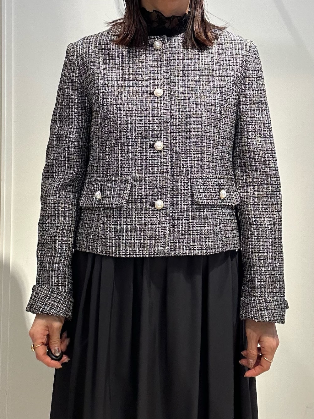 ブラック系のノーカラージャケット、ブラック系のTシャツ/カットソー、ブルー系のスカートを着用したレディースの冬コーディネートの4枚目の写真