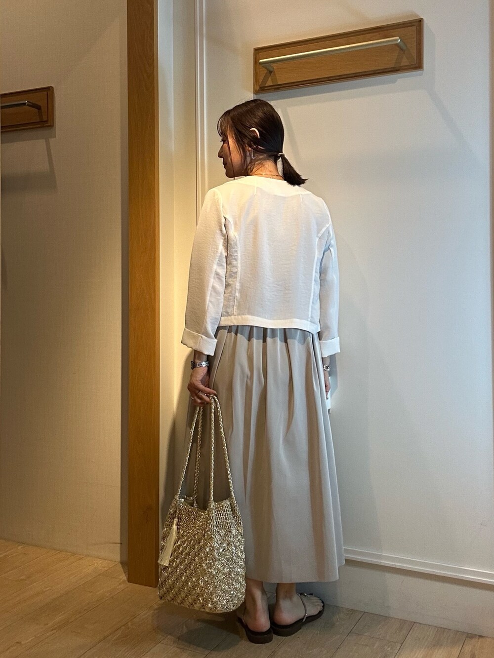 ホワイト系のブルゾン、グレー系のTシャツ/カットソー、グリーン系のスカートを着用したレディースの春コーディネートの4枚目の写真