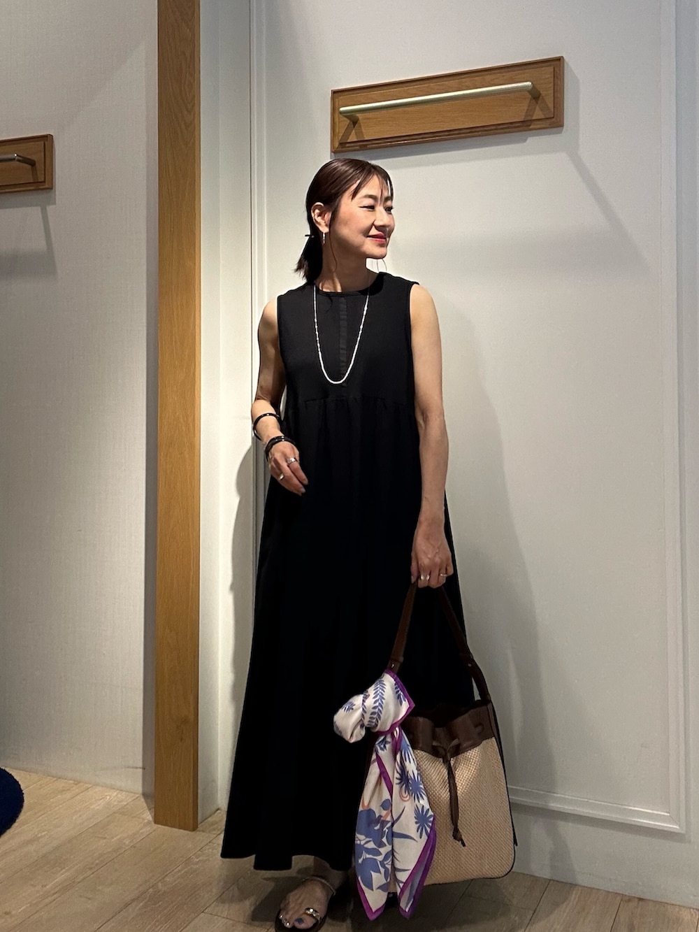 ホワイト系のニット/セーター、ブラック系のワンピース、ブラック系のサンダルを着用したレディースの夏コーディネートの9枚目の写真