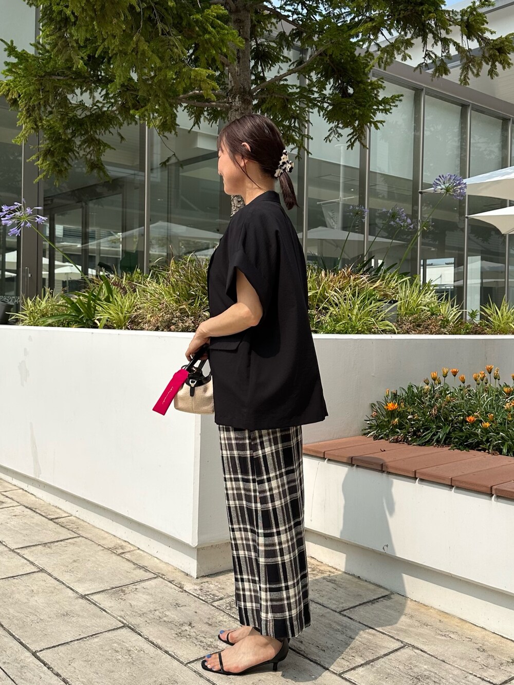 ブラック系のテーラードジャケット、ホワイト系のTシャツ/カットソー、ブラック系のバックパック/リュックを着用したレディースの夏コーディネートの2枚目の写真