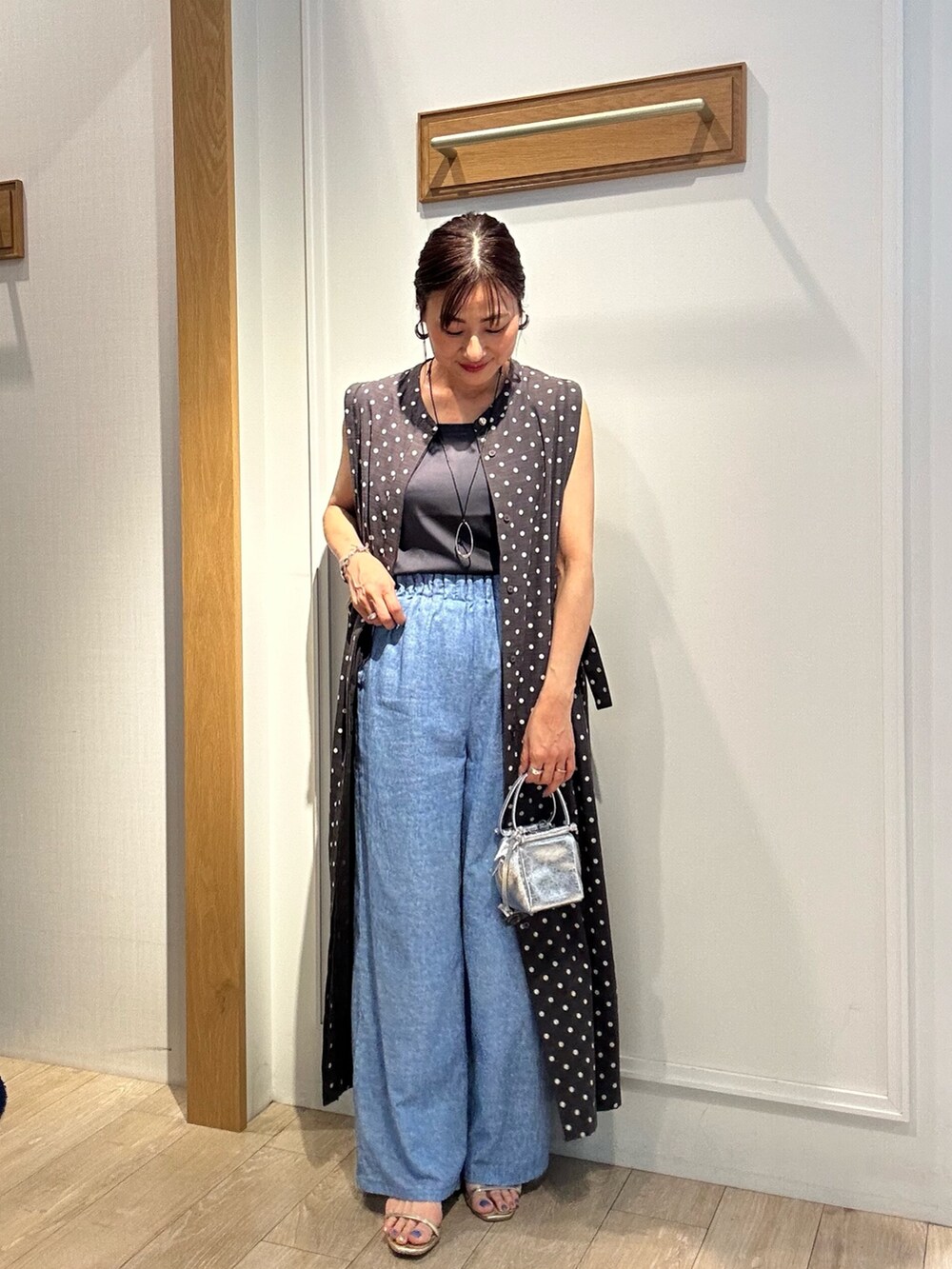 シルバー系のニット/セーター、グレー系のワンピース、ベージュ系のボストンバッグを着用したレディースの夏コーディネートの10枚目の写真