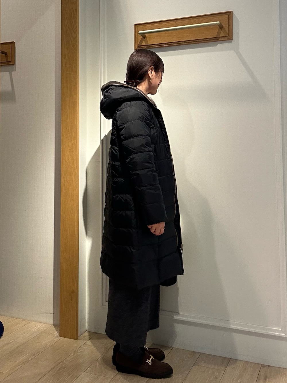 ブラック系のダウンジャケット/コート、グレー系のスカート、ブラック系のトートバッグを着用したレディースの冬コーディネートの2枚目の写真