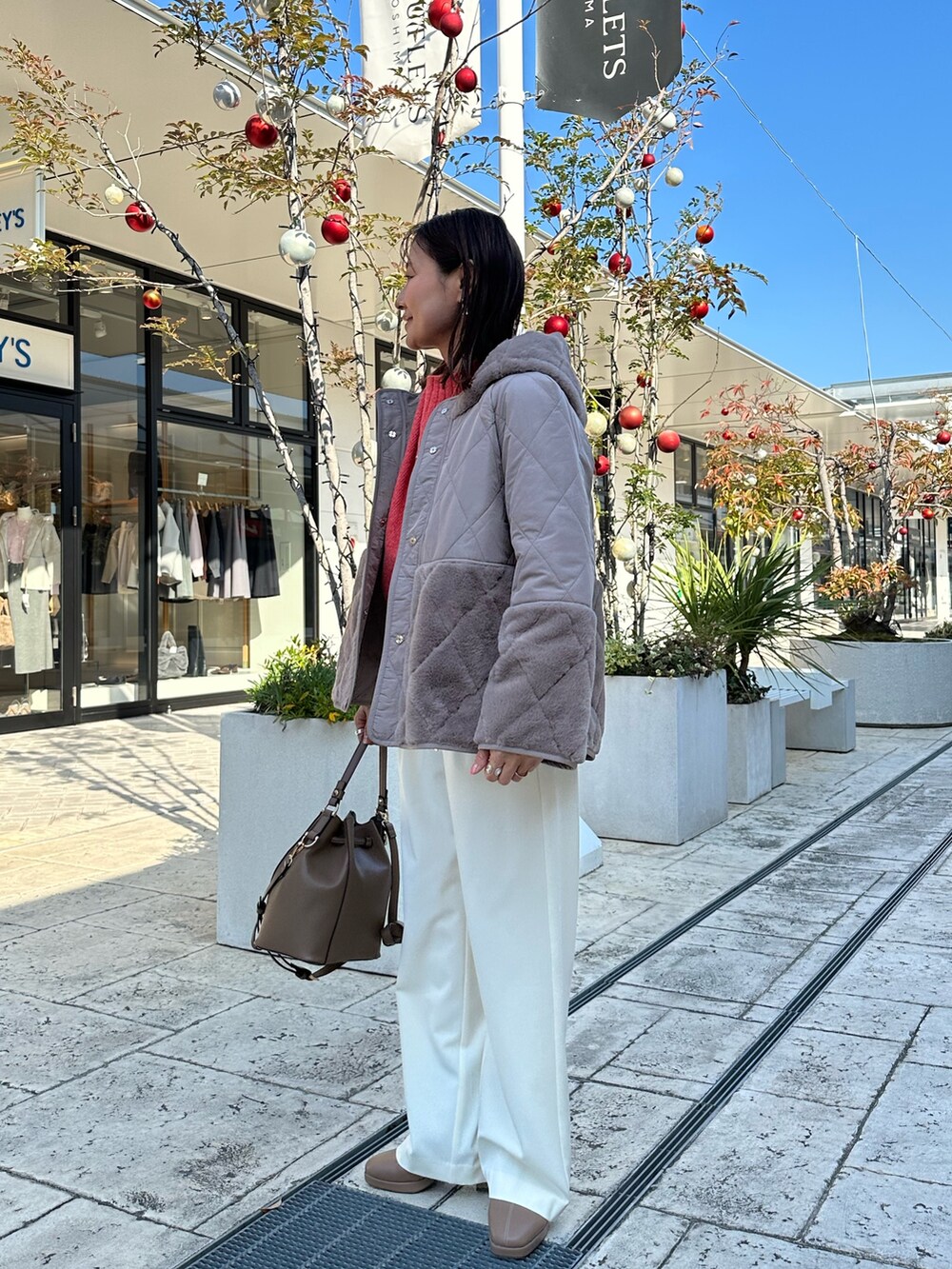 ブラウン系のブルゾン、オレンジ系のニット/セーターを着用したレディースの冬コーディネートの2枚目の写真