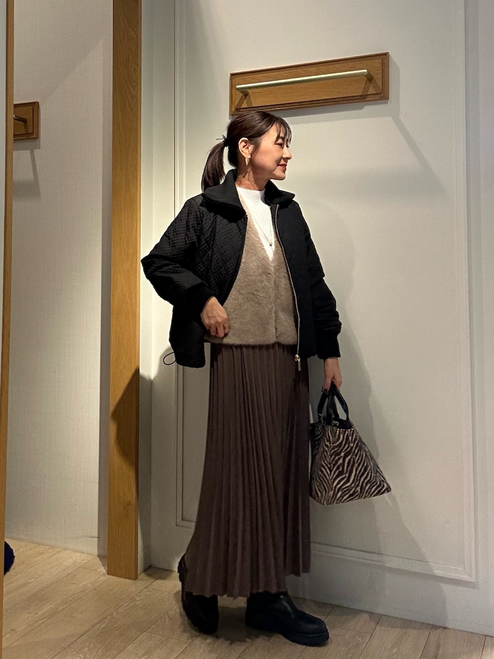 ブラウン系のブルゾン、ホワイト系のニット/セーター、ブラウン系のスカートを着用したレディースの秋コーディネートの5枚目の写真